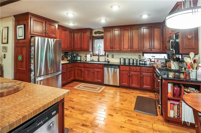 12 Woodland Trl, Warrensburg, MO 64093 - kitchen featuring appliances with stainless steel finishes, a sink, light wood finished floors, decorative backsplash, and recessed lighting
