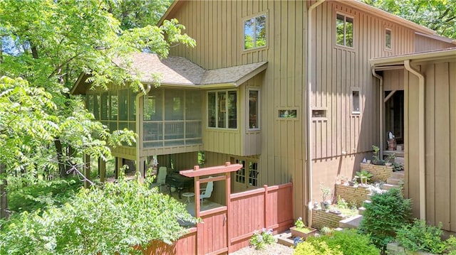 12 Woodland Trl, Warrensburg, MO 64093 - rear view of house featuring a sunroom and roof with shingles