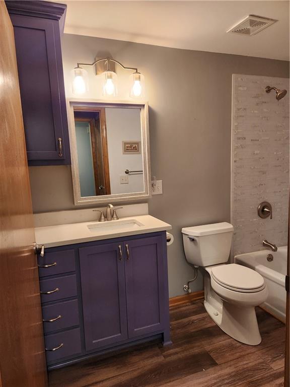 15921 Cantrell Rd, Bonner Springs, KS 66012 - full bathroom featuring wood finished floors, vanity, and shower / bathtub combination