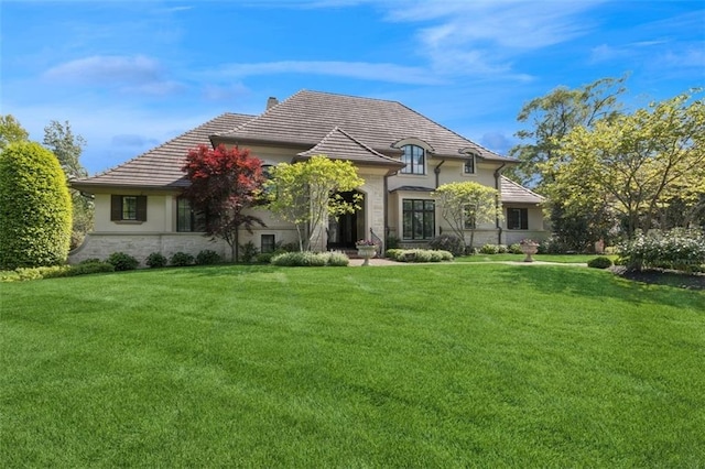 1901 Stratford Rd, Mission Hills, KS 66208 - french provincial home with a front lawn, stone siding, a tile roof, and stucco siding