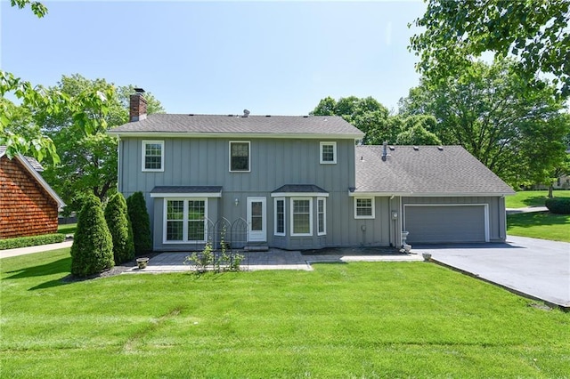 12012 Ensley Ln, Leawood, KS 66209 - rear view of property featuring a chimney, driveway, a garage, and a yard