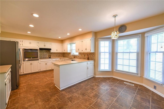 12012 Ensley Ln, Leawood, KS 66209 - kitchen featuring stainless steel appliances, a sink, a peninsula, white cabinets, and recessed lighting