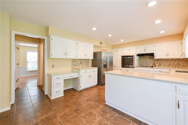12012 Ensley Ln, Leawood, KS 66209 - kitchen with stainless steel appliances, under cabinet range hood, backsplash, stone tile floors, and recessed lighting