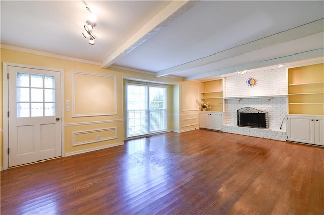 12012 Ensley Ln, Leawood, KS 66209 - unfurnished living room with plenty of natural light, wood finished floors, beamed ceiling, a brick fireplace, and a decorative wall