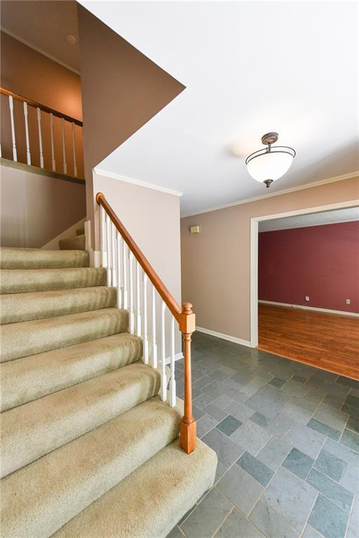 12012 Ensley Ln, Leawood, KS 66209 - stairs with crown molding, baseboards, and stone finish flooring