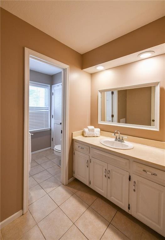 12012 Ensley Ln, Leawood, KS 66209 - bathroom with vanity, toilet, tile patterned flooring, and baseboards
