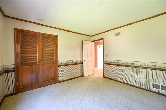 12012 Ensley Ln, Leawood, KS 66209 - unfurnished bedroom featuring carpet, a closet, wainscoting, and ornamental molding