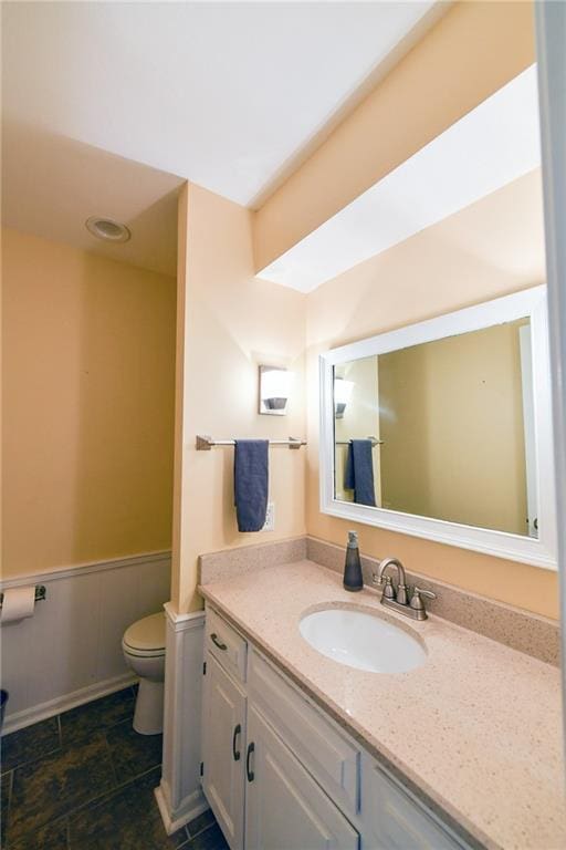 12012 Ensley Ln, Leawood, KS 66209 - bathroom featuring toilet, vanity, and wainscoting