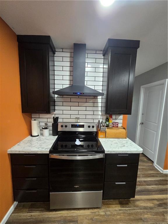 1824 S Grand Ave, Sedalia, MO 65301 - kitchen featuring tasteful backsplash, dark wood-style floors, wall chimney exhaust hood, and stainless steel range with electric stovetop