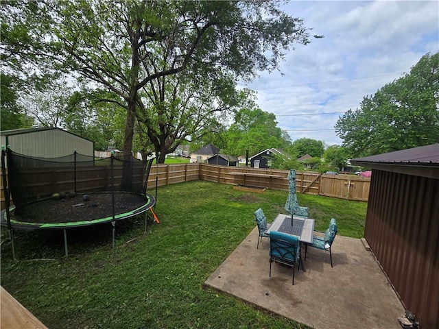 1824 S Grand Ave, Sedalia, MO 65301 - view of yard featuring outdoor dining area, a fenced backyard, a trampoline, and a patio area