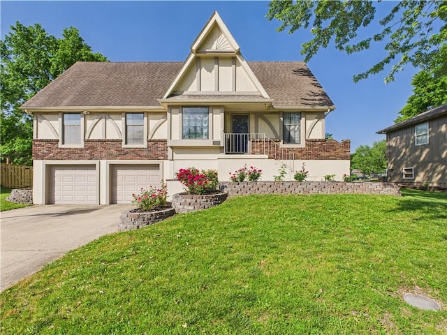 tudor-style house featuring an attached garage, a front lawn, concrete driveway, stucco siding, and brick siding