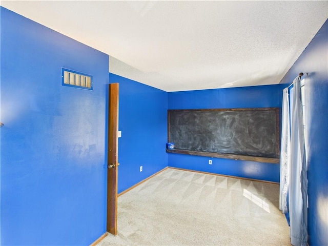 carpeted cinema with baseboards and a textured ceiling