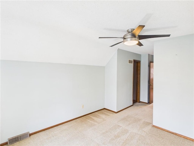 additional living space featuring light carpet, ceiling fan, baseboards, and lofted ceiling