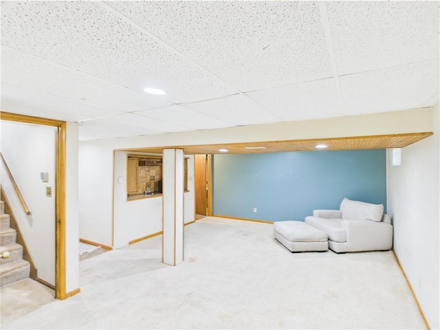 finished below grade area with stairway, light carpet, and baseboards