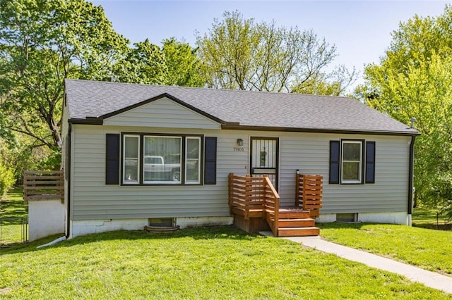 single story home featuring a front yard, roof with shingles, and fence