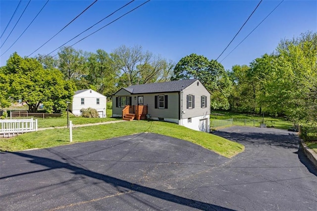 view of front of property with fence, a garage, a front lawn, and driveway