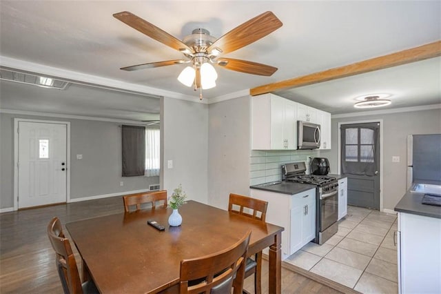 dining space featuring crown molding, baseboards, a ceiling fan, and visible vents
