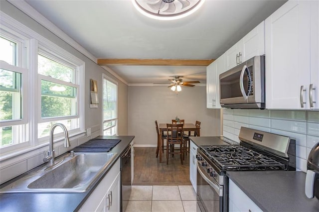 kitchen with ceiling fan, a sink, dark countertops, white cabinets, and appliances with stainless steel finishes
