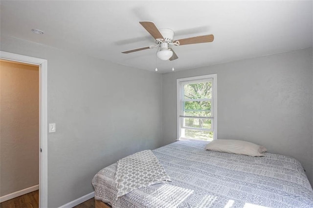 bedroom featuring a ceiling fan, wood finished floors, and baseboards