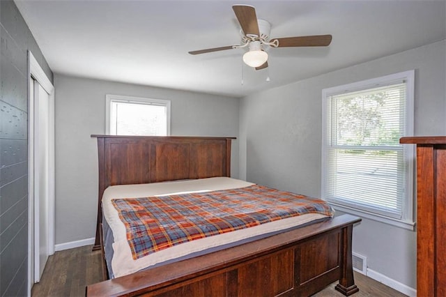 bedroom with ceiling fan, baseboards, visible vents, and wood finished floors