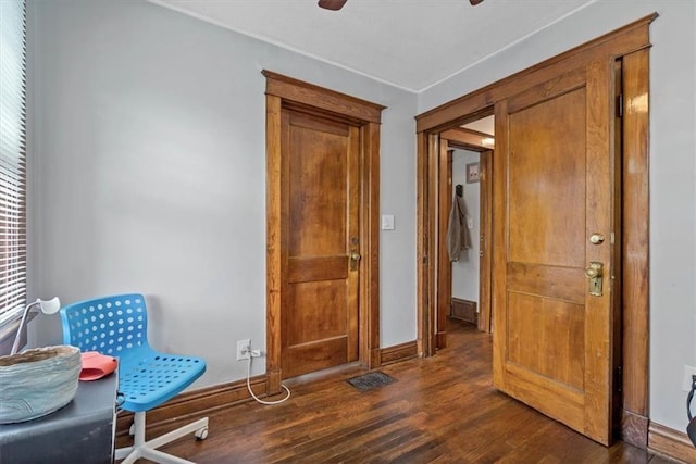 sitting room with dark wood-type flooring, baseboards, and ceiling fan