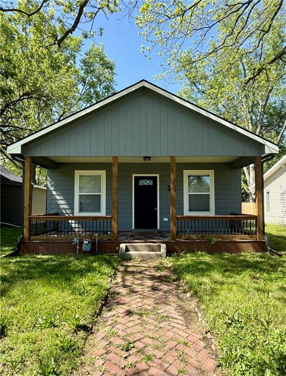 bungalow-style home with a porch and a front yard