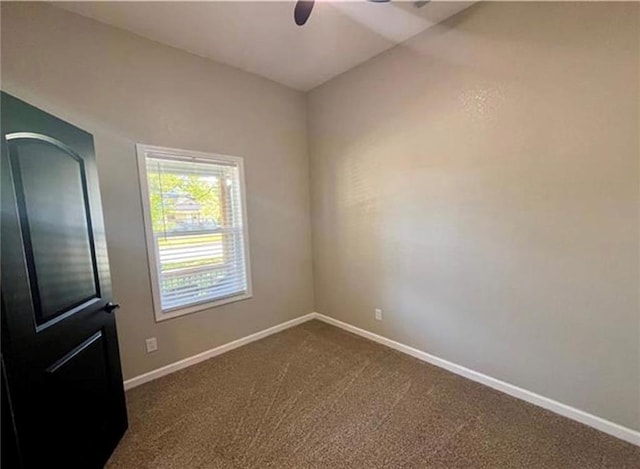 unfurnished room featuring a ceiling fan, baseboards, and dark colored carpet