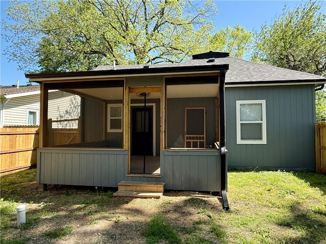 view of front of home featuring entry steps, a sunroom, and a shingled roof