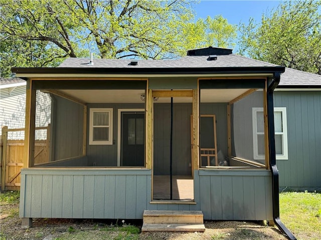 back of property featuring a sunroom, a shingled roof, and entry steps