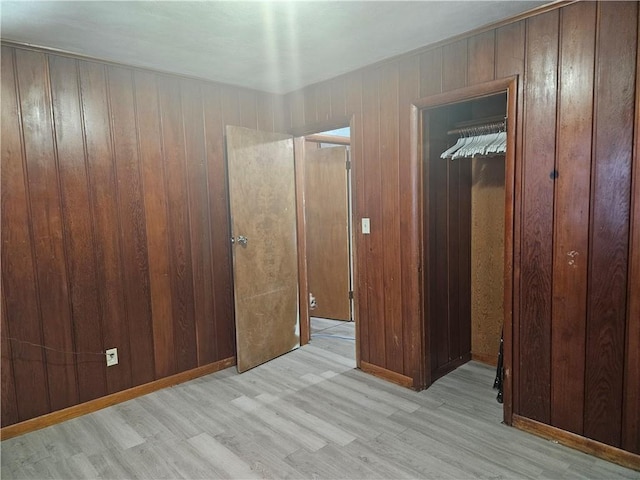 unfurnished bedroom with wood walls and wood finished floors