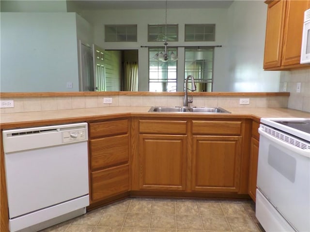kitchen with a sink, white appliances, brown cabinetry, backsplash, and light countertops