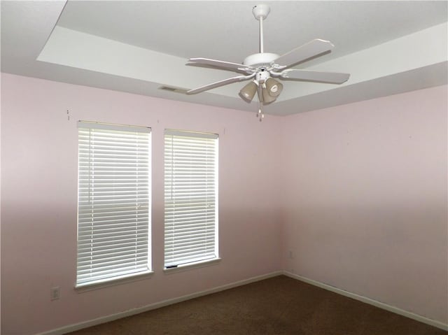 carpeted spare room featuring baseboards and ceiling fan