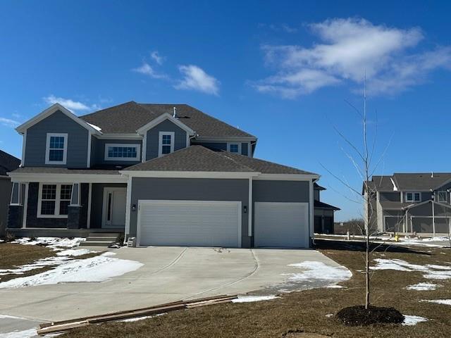 view of front of property featuring an attached garage, concrete driveway, and a porch