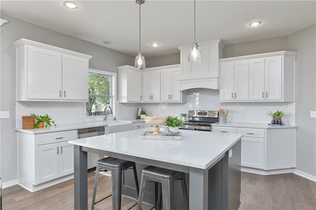 kitchen with light countertops, a sink, a breakfast bar, and stainless steel appliances