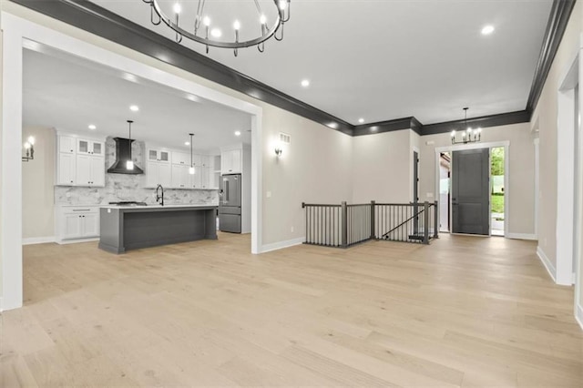 2608 NE Amanda Ln, Blue Springs, MO 64029 - unfurnished living room featuring a chandelier, light wood finished floors, ornamental molding, and recessed lighting