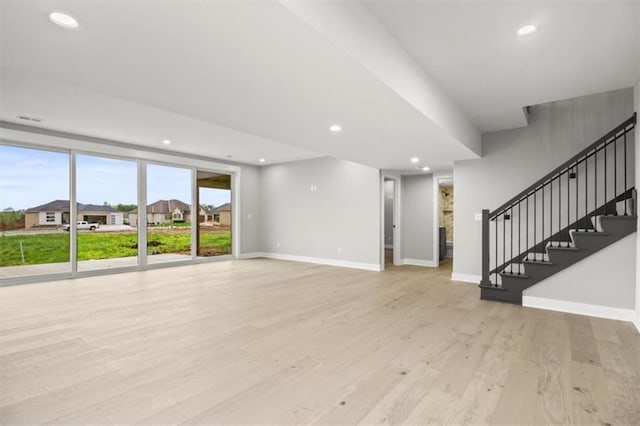 2608 NE Amanda Ln, Blue Springs, MO 64029 - unfurnished living room featuring light wood-style flooring, recessed lighting, and stairs