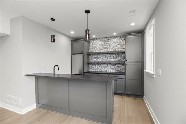 2608 NE Amanda Ln, Blue Springs, MO 64029 - bar with freestanding refrigerator, light wood-type flooring, recessed lighting, and hanging light fixtures