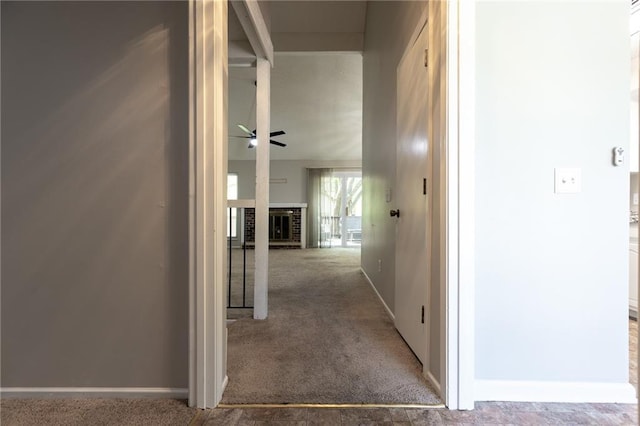 hallway featuring carpet floors and baseboards