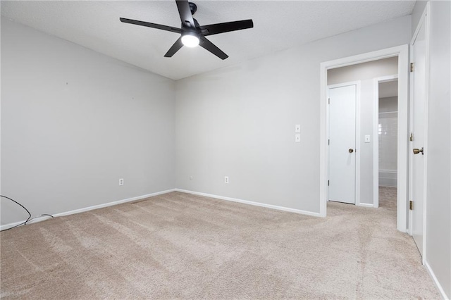 unfurnished room featuring light carpet, a ceiling fan, and baseboards