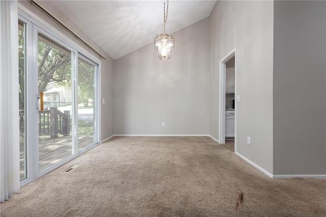 carpeted spare room featuring vaulted ceiling, baseboards, and a chandelier