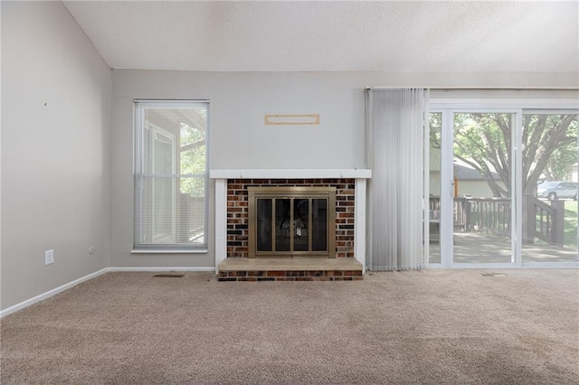 unfurnished living room featuring carpet, a brick fireplace, and baseboards