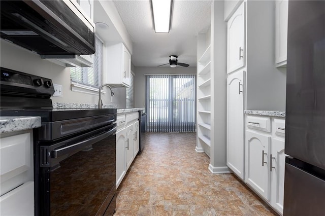 kitchen with electric range, stainless steel microwave, ceiling fan, freestanding refrigerator, and white cabinets
