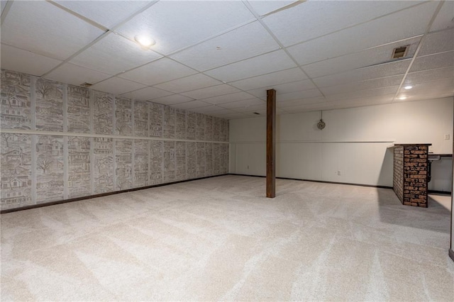 finished basement with carpet floors, a drop ceiling, and baseboards
