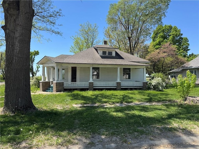 318 S Williams St, Craig, MO 64437 - bungalow-style home with covered porch, roof with shingles, a chimney, and a front yard