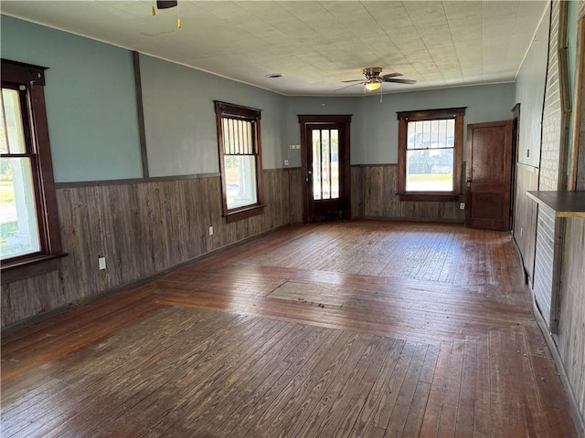 318 S Williams St, Craig, MO 64437 - unfurnished room featuring wooden walls, a wainscoted wall, ceiling fan, and hardwood / wood-style flooring