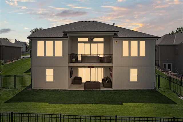 back of house at dusk with a balcony, a patio, outdoor lounge area, and roof with shingles