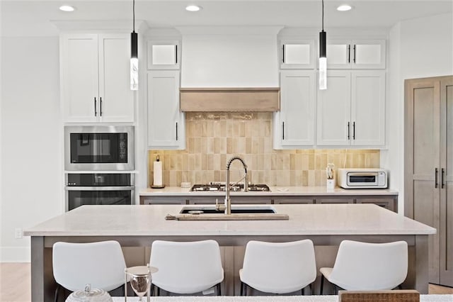 kitchen with stainless steel appliances, a breakfast bar, tasteful backsplash, and recessed lighting