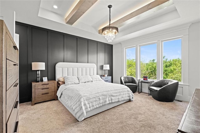 bedroom with a decorative wall, multiple windows, light colored carpet, and a chandelier