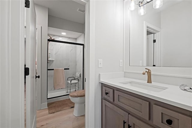 full bathroom featuring a marble finish shower, wood finished floors, toilet, vanity, and recessed lighting