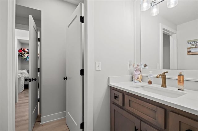 bathroom featuring wood finished floors, vanity, and baseboards